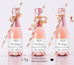 three bottles of champagne with straws tied to them, one is pink and the other is white