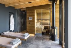 an indoor sauna room with two beds and a wood burning stove