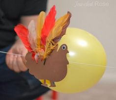 a person holding a balloon with a turkey head on it's side and a string attached to it