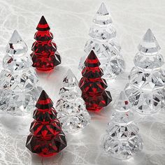 several red and clear glass christmas trees on a white surface