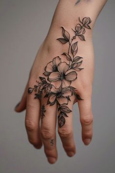 a woman's hand with a flower tattoo on it