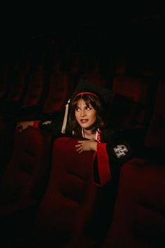 a woman sitting in the middle of a movie theater with her hands on her hips