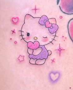 a hello kitty tattoo with hearts and stars on the side of her stomach is shown