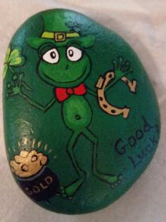 a painted rock with an image of a frog on it