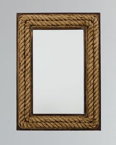 a wooden frame with rope around it and a mirror on the wall in front of it