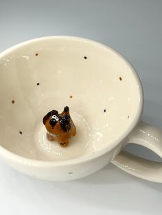 a dog figurine sitting in a white bowl