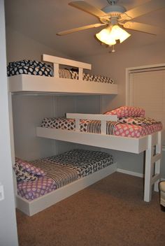 two bunk beds sitting next to each other in a room with carpeted flooring