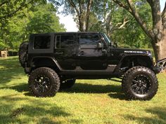 a black jeep is parked in the grass