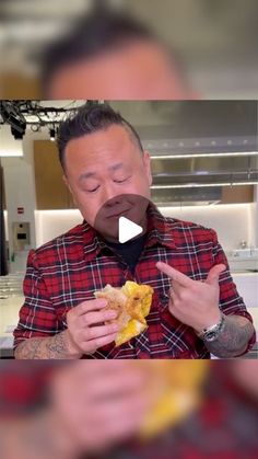 a man eating a sandwich with his eyes closed