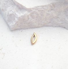 a small gold ring sitting on top of a white rock