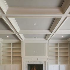 an empty living room with built - in bookcases and a fireplace