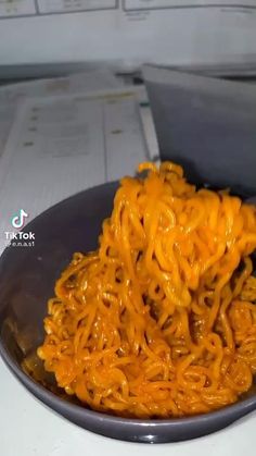 a bowl filled with noodles on top of a table