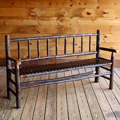 a wooden bench sitting on top of a wooden floor next to a wood paneled wall