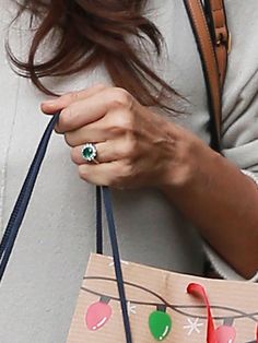 a woman holding a paper bag with christmas decorations on it