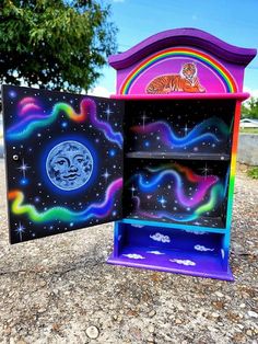 a colorful painted bookcase with a tiger on the moon