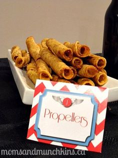 a plate with some food on it next to a bottle of wine and a sign that says propellers