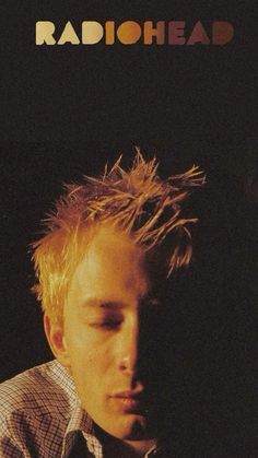 a man with his eyes closed in front of a radiohead sign that says radiohead