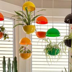 hanging planters with plants in them are colorfully decorated by the window sill