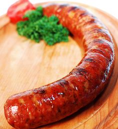 there is a large sausage on the wooden plate