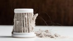 a close up of a cup on a table with some stuff in the bottom half