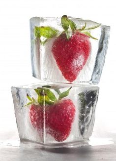 ice cubes with strawberries and leaves in them