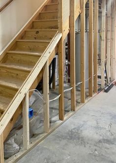 an unfinished staircase in a house being built with wood framing and construction materials on the floor