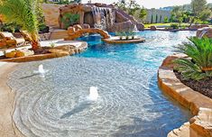 an outdoor swimming pool with water features