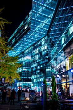 people are walking in front of an illuminated building