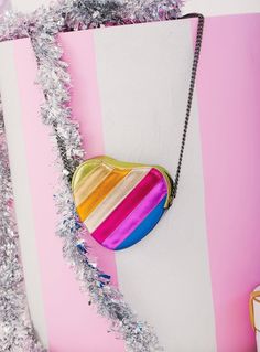 Features a vibrant, multicolored striped pattern on a heart-shaped design. Equipped with a sturdy and stylish chain strap for crossbody or shoulder wear. This purse is a statement piece, ensuring you stand out wherever you go. Material & Care: Material: High-quality synthetic leather with a durable metal chain strap. Care: Wipe clean with a soft, damp cloth. Avoid exposure to excessive moisture and direct sunlight. Store in a dust bag when not in use to maintain its vibrant colors and shape. Heart Purse, Wrap Carrier, Copper Pearl, Rainbow Heart, Girls Sneakers, The Boys, Synthetic Leather, Girls Accessories, Metal Chain