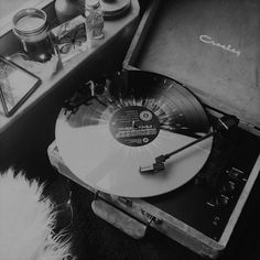 an old record player sitting on top of a table next to a suitcase and other items