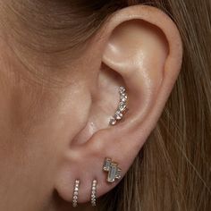 a woman's ear is shown with three different types of piercings