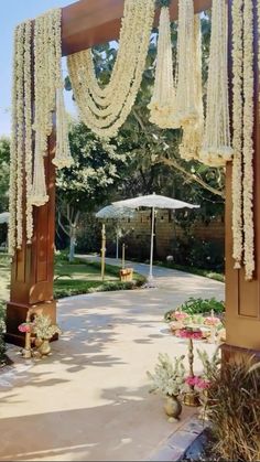 an outdoor wedding venue with flowers and umbrellas