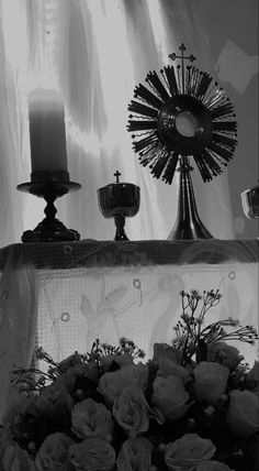 flowers and candles sit on a mantle in front of a window