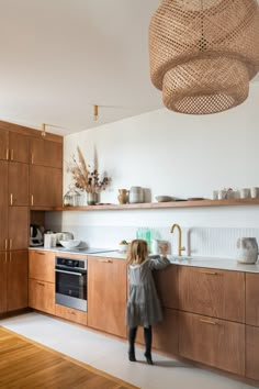 a woman standing in a kitchen next to a sink