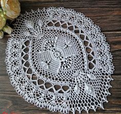 two white doily on a wooden table with flowers