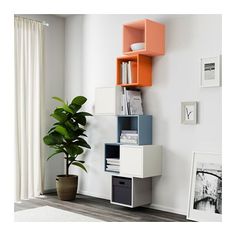 a white and orange book shelf next to a potted plant