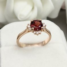 This beautiful ring is made from genuine 925 sterling silver with rose gold plating. Ring details- -The Main stone is a round cut 7mm Natural Garnet Stone -Side stones are round 1.1mm and 1.3mm simulated diamonds -Ring is casted in solid 925 sterling silver with rose gold plating (yellow gold and rhodium plated also available, please check the drop down menu for more options) -The Total face height of the ring measures 10mms and the band width measures 2mms -Each ring is handmade, so please allo 14k Rose Gold Ruby Ring, Rose Gold Birthstone Ring With Prong Setting For Proposal, Classic Rose Gold Halo Ring, Classic Ruby Ring With Halo Design As Gift, Rose Gold Ruby Ring With Halo Setting For Anniversary, Classic Rose Gold Cluster Ring With Prong Setting, Rose Gold Ruby Ring With Halo Setting For Wedding, Rose Gold Halo Setting Wedding Ring With Round Band, 14k Rose Gold Halo Ring