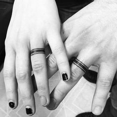 two people with rings on their fingers holding each other's hands and looking at the camera