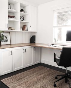 a home office with white cabinets and black chair in front of the desk is an area rug