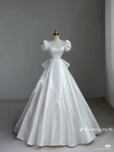 a white wedding dress on display in front of a window