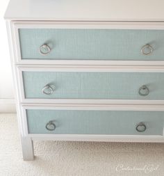 a white dresser with blue drawers and knobs