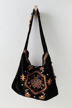 So sweet in floral, this soft velvet tote features stunning flower embroidery and mirror details for the ultimate free-spirit bag. **Features:** Slouchy style, soft velvet fabrication, long shoulder strap, inner zipper compartment, embroidered floral designs, mirror details, hidden snap closure, wood beaded tassel **Why We | Vic Velvet Slouchy Bag by FP Collection at Free People in Black Free People Bag, Spirit Bags, Slouchy Bag, Slouchy Style, Earthy Outfits, Charity Shop, Pretty Bags, Embroidered Bag