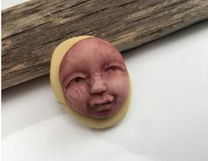 a close up of a wooden stick with a face on it