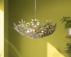 a chandelier hanging from a ceiling in a room with green walls and potted plants