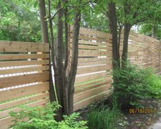 a wooden fence surrounded by trees and bushes