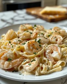 a white plate topped with pasta and shrimp