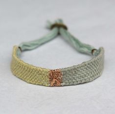 a close up of a bracelet on a white surface with a knot around the clasp