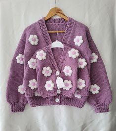 a purple sweater with white flowers on it