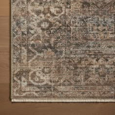 an area rug that is on top of a wooden floor with a brown and tan color scheme