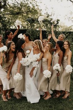 a group of women standing next to each other holding bouquets in front of them